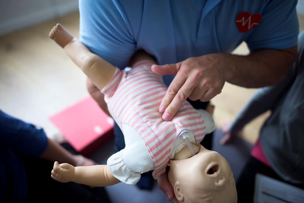Matrona demostrando maniobras de primeros auxilios basicos en muneco de bebe en Valencia